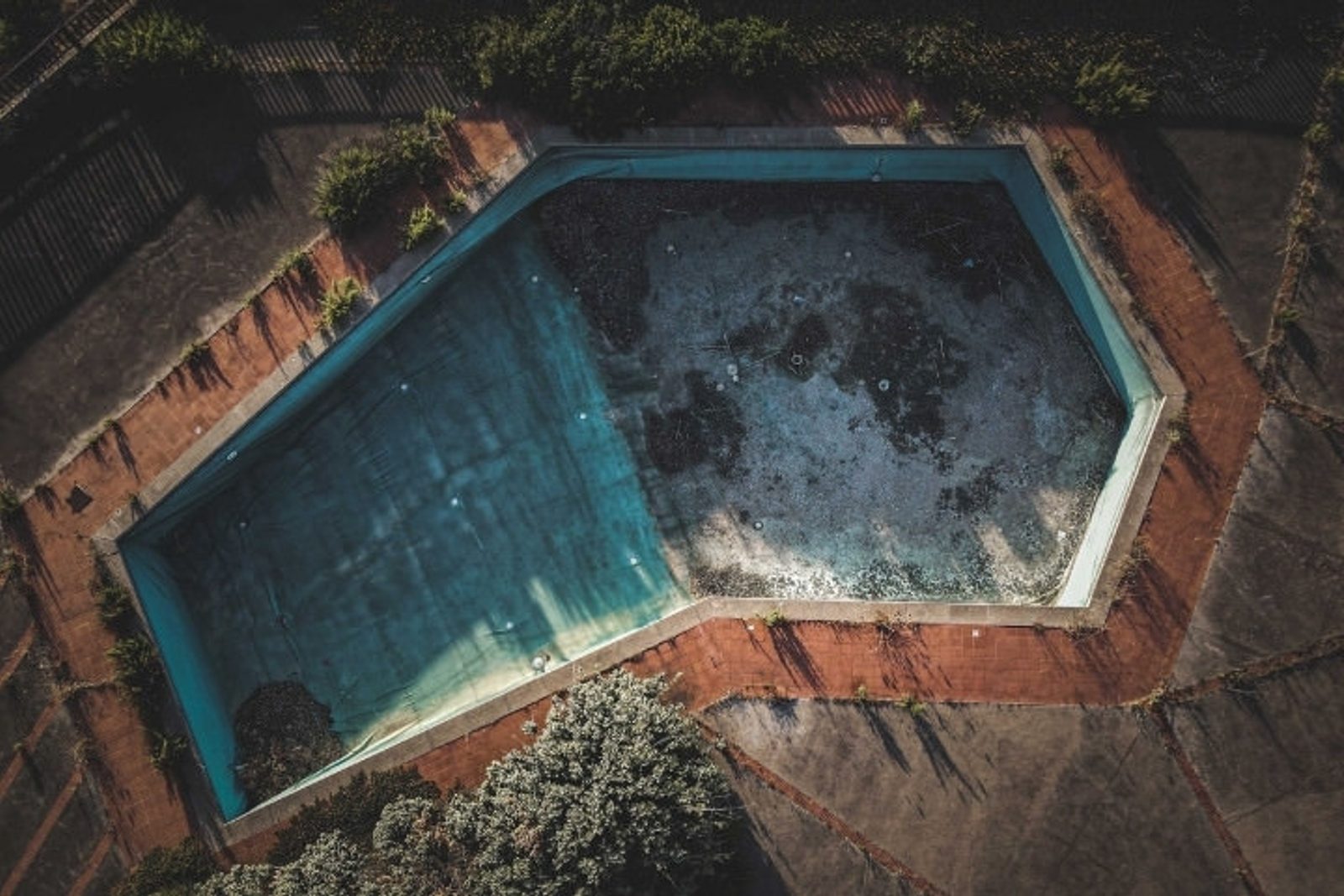 Outdated backyard pool inspected to compare renovation versus full new build