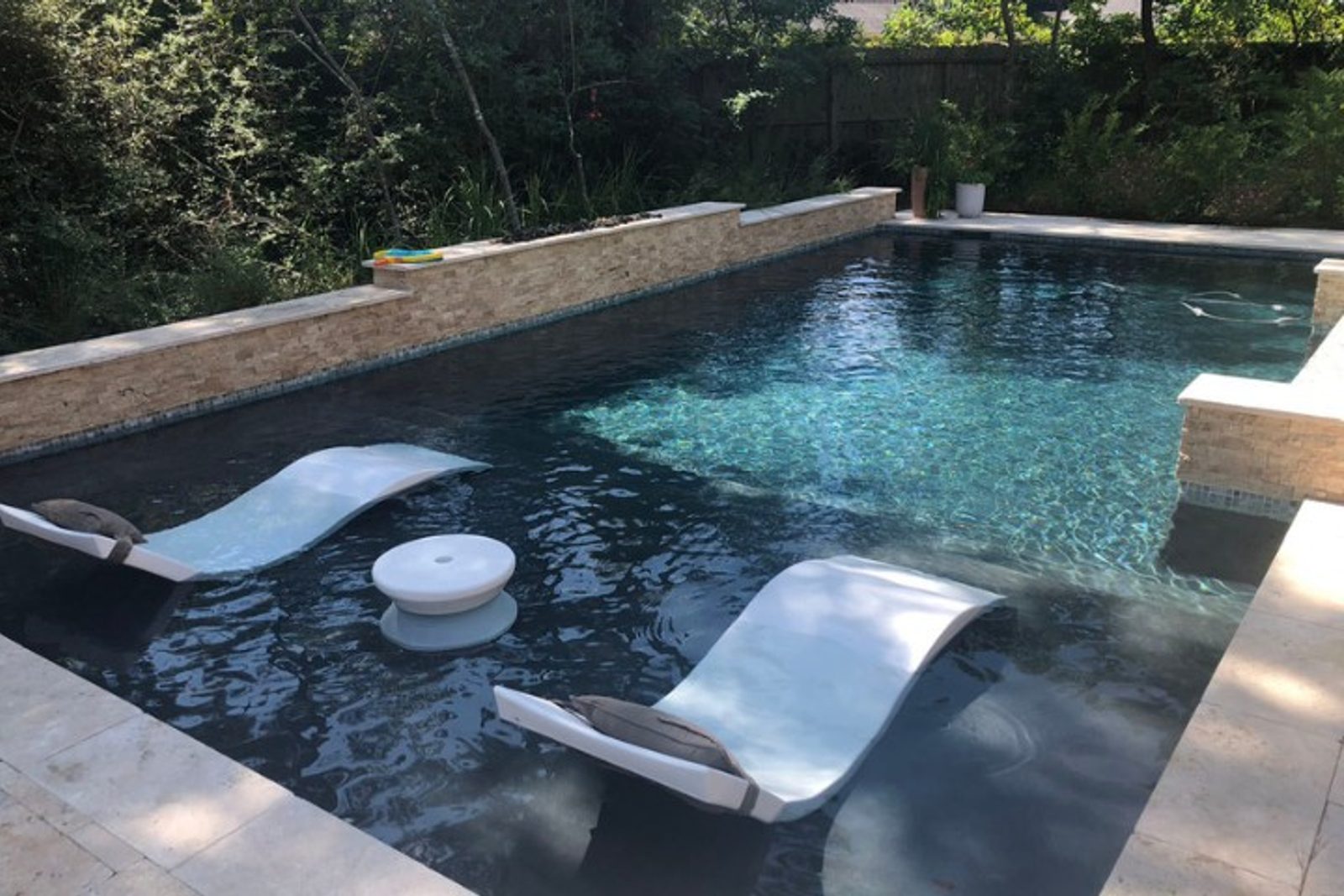 Renovated pool tanning ledge perfect for sunbathing and family relaxation