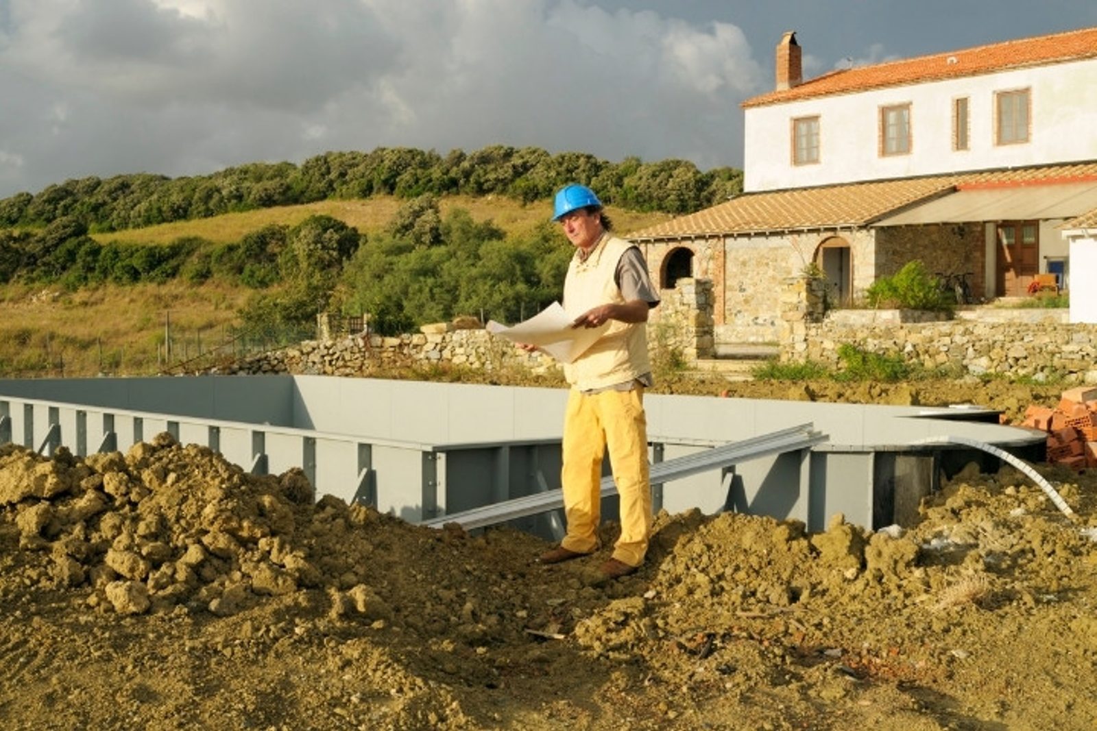 Pool builder checking construction progress on site