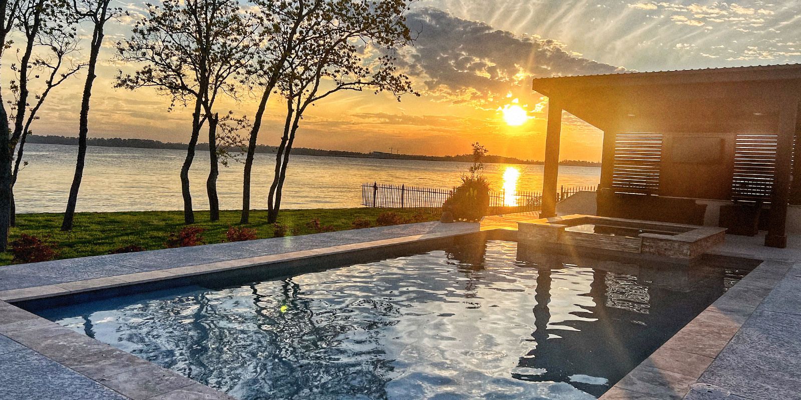 Sunset over a backyard pool and patio