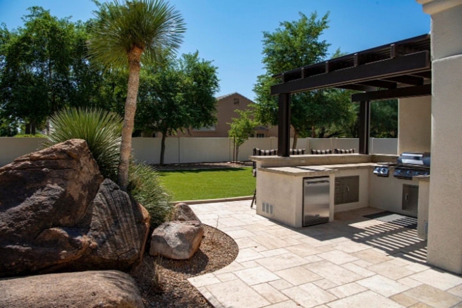 Houston backyard kitchen design with grill, covered prep area, and modern hardscaping