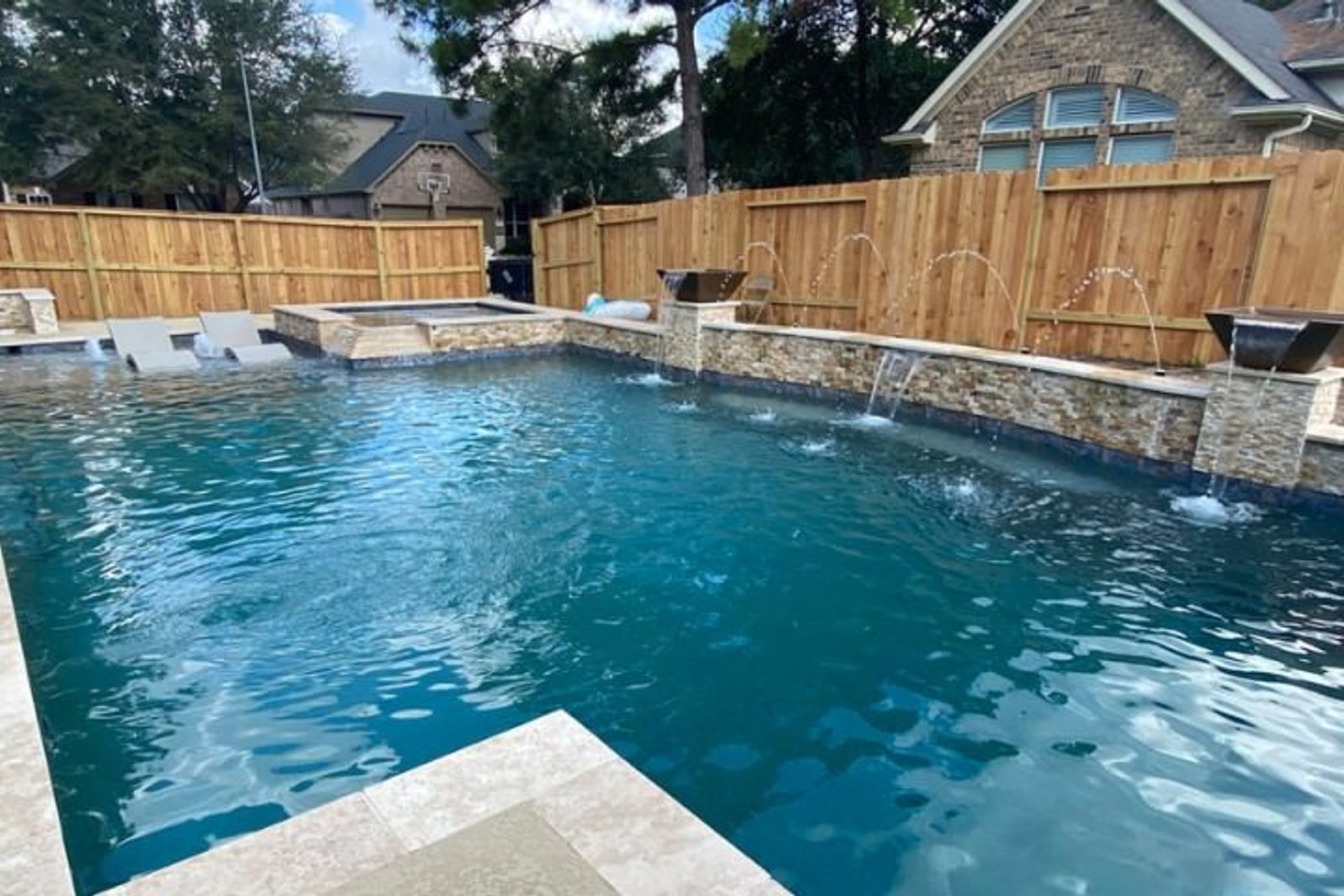 A beautifully designed pool with synchronized deck jets enhancing the outdoor ambiance
