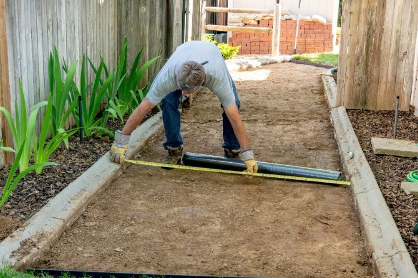 Outdoor living contractor measuring an outdoor area during the planning stage of a Houston outdoor kitchen project