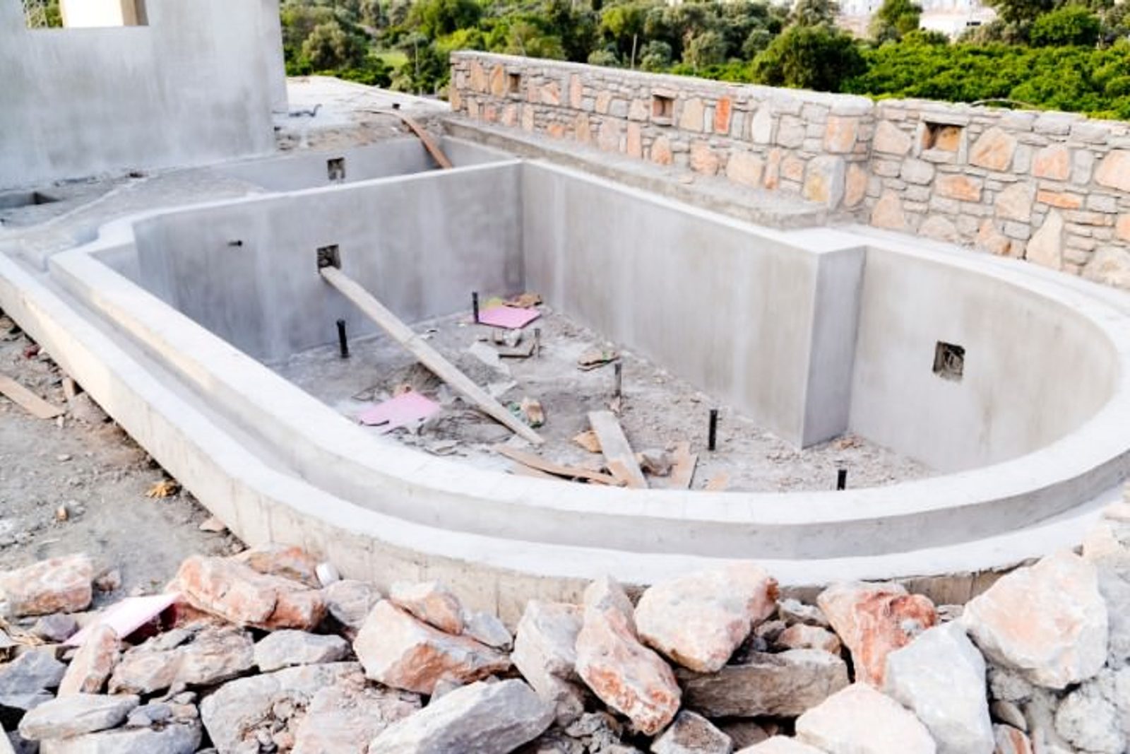 Pool installation phase showing shell, rebar, and site prep