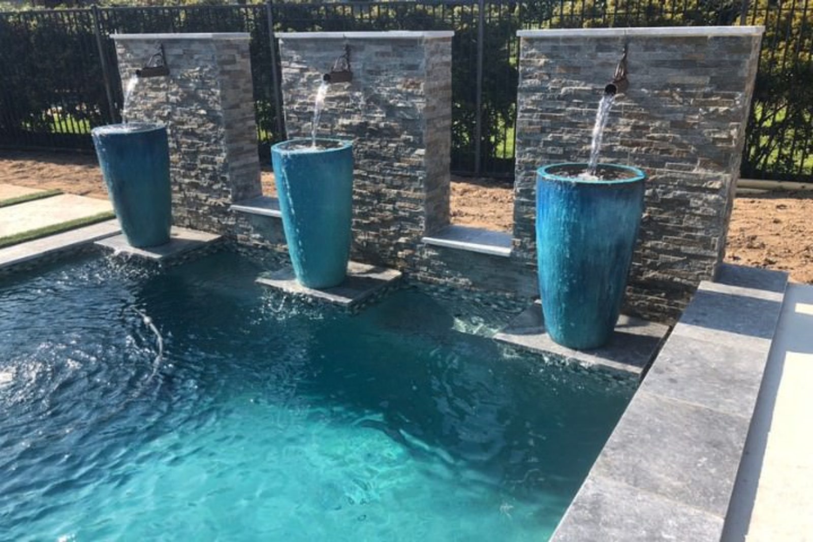 Backyard pool with elegant scupper water features, creating a smooth and continuous flow