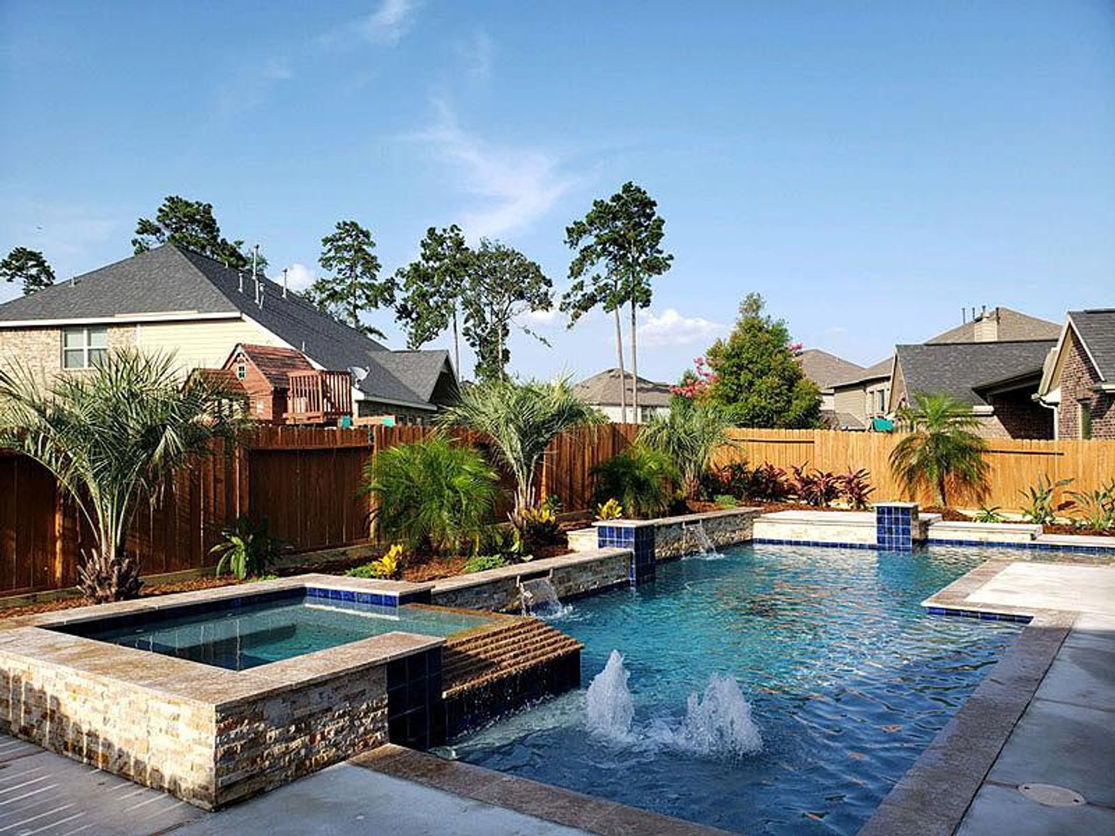Luxury pool design with built-in spa and water fountains