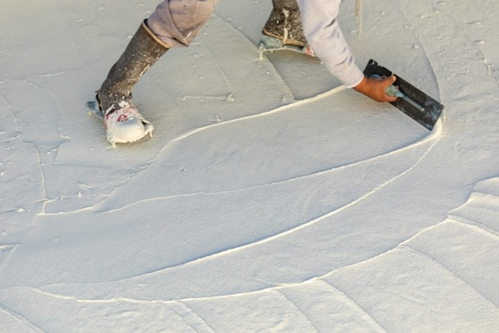 Pool contractor applying plaster coating on the interior surface during finishing stage