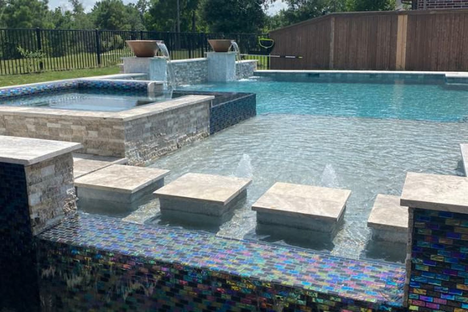 High-end custom-built pool featuring integrated waterfalls, spa, and bubblers for a resort-like experience