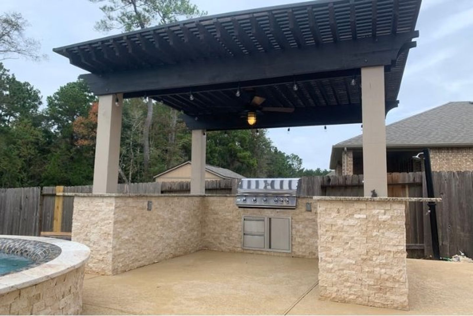 outdoor kitchen with built-in grill and large covered pergola