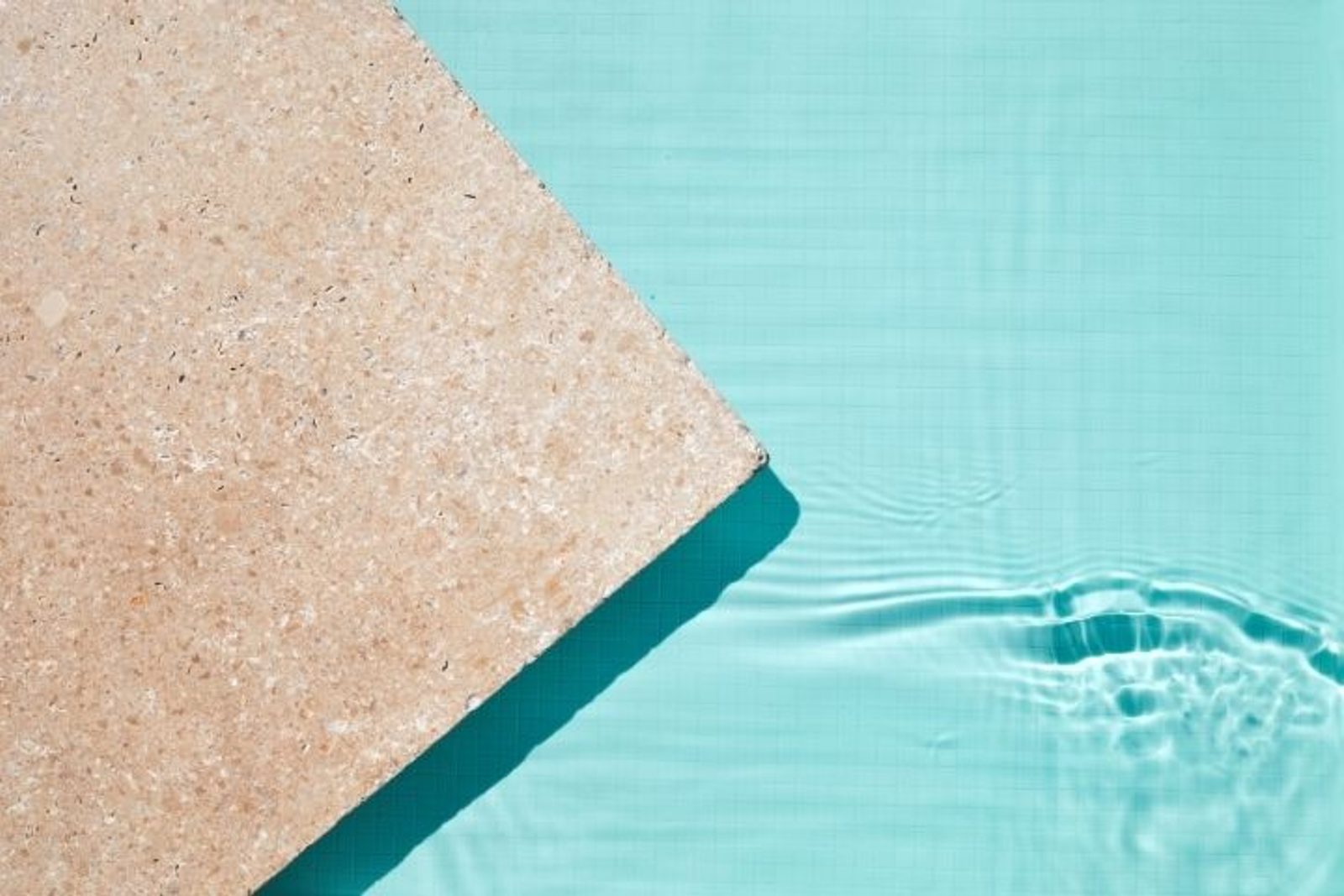 Textured travertine pool edge suited for a warm Houston pool patio