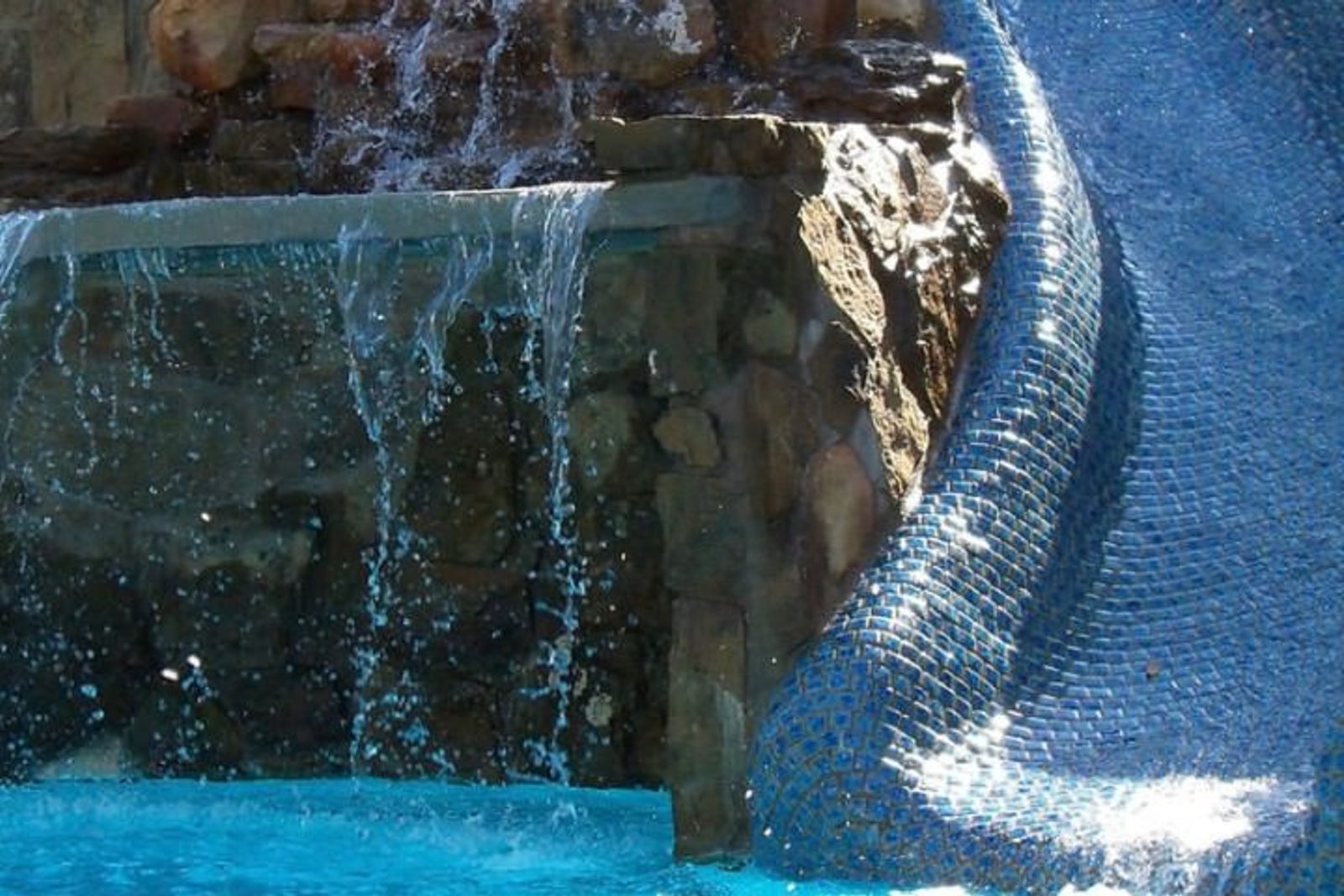 Custom-built grotto water feature with cascading waterfalls and a shaded retreat