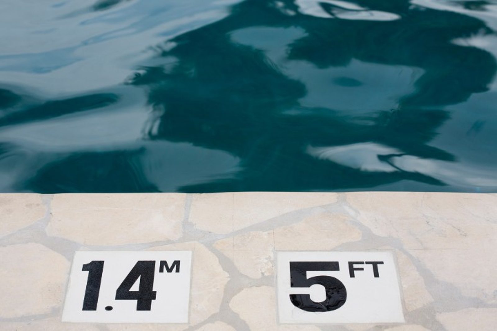 Safety depth markers installed beside a swimming pool