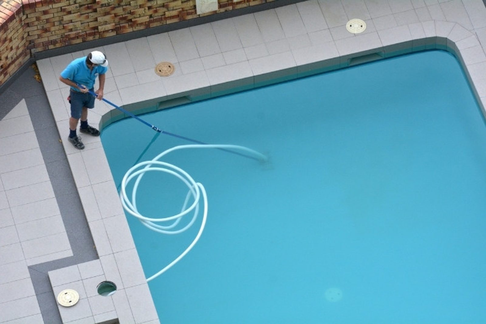 Pool technician cleaning cloudy swimming pool water