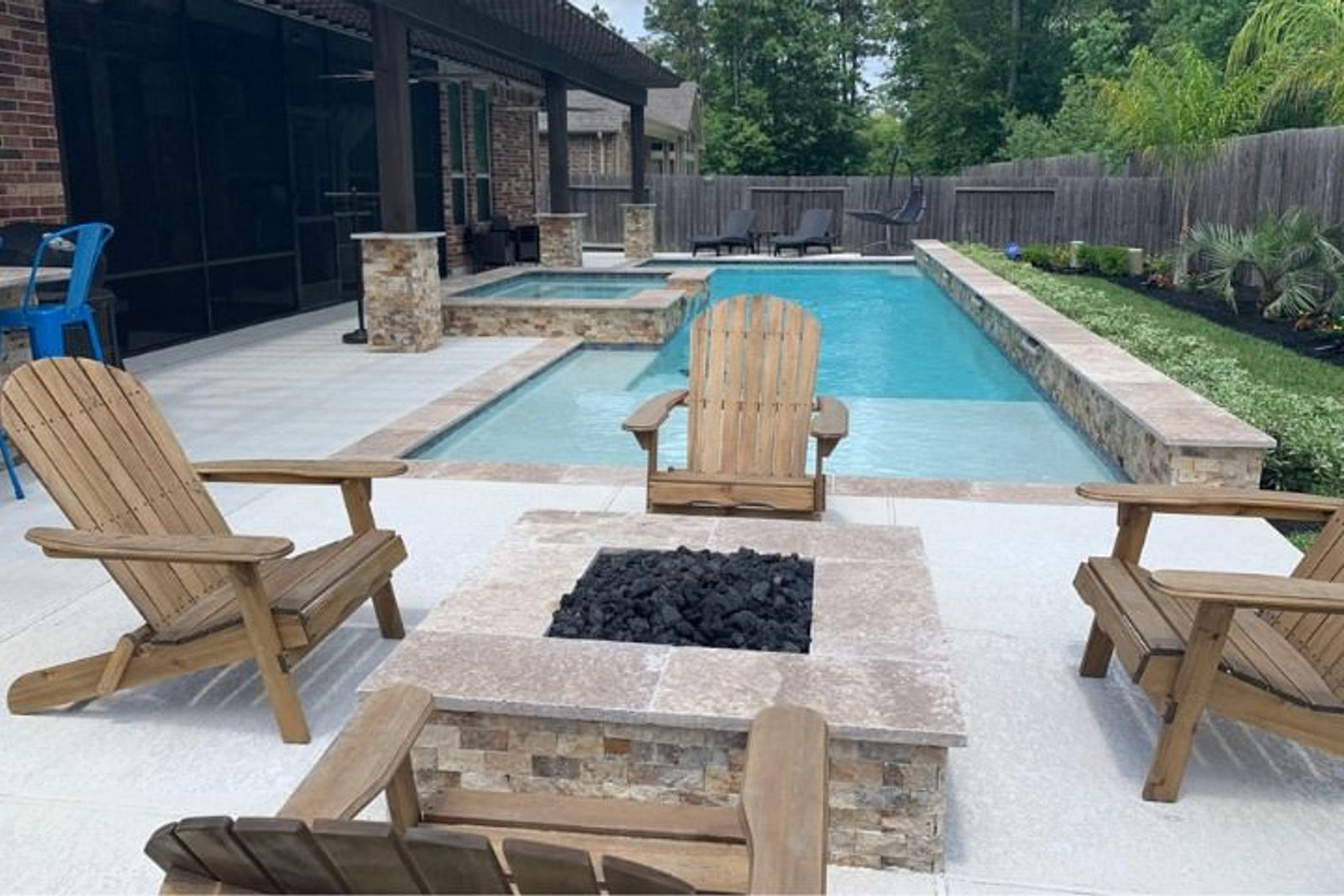 Custom-designed firepit blending beautifully with a landscaped pool area
