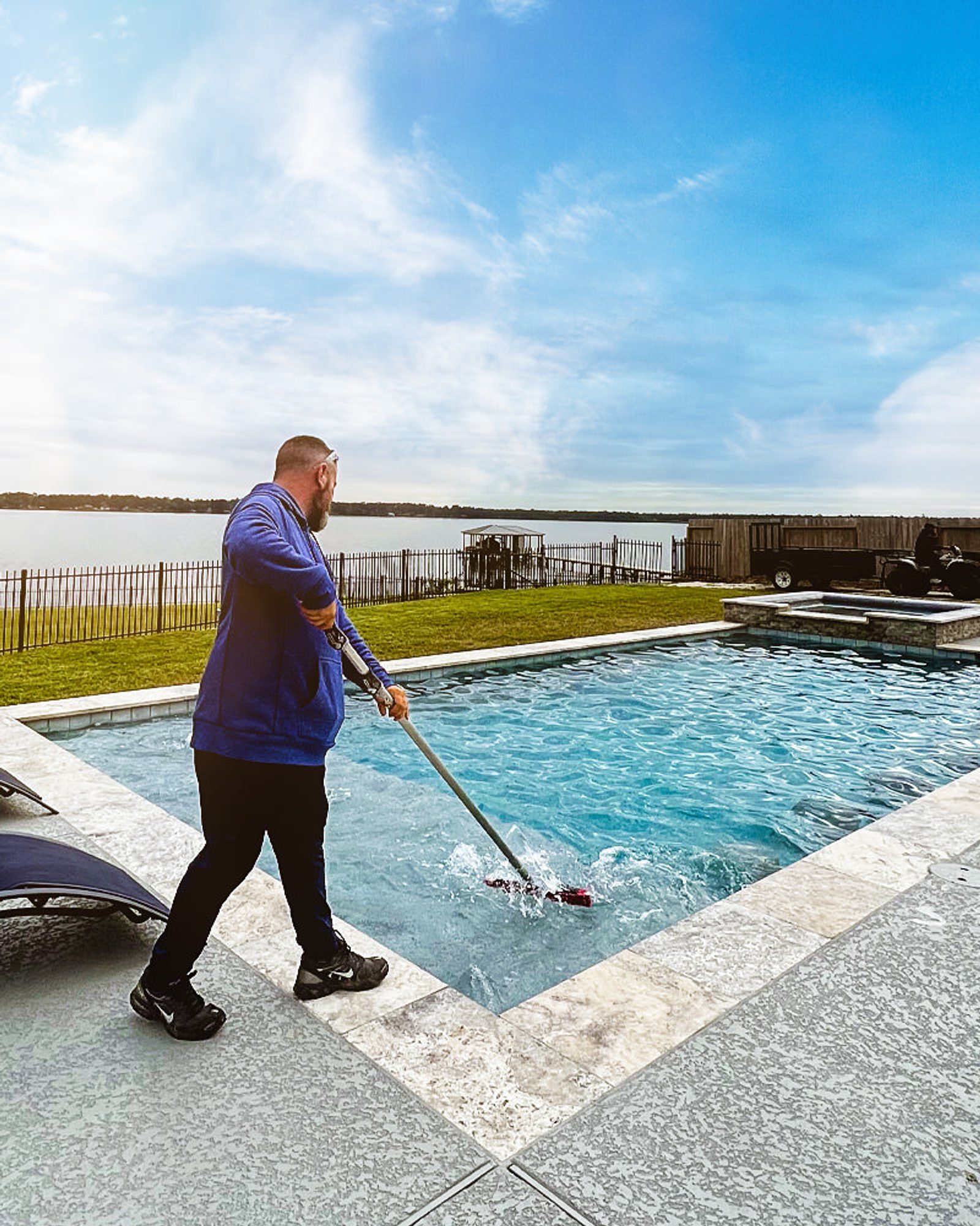 Pool technician cleaning residential swimming pool in Houston