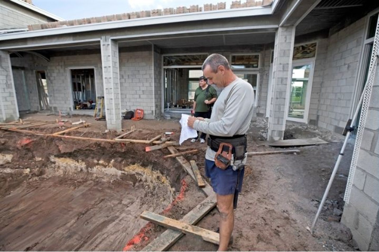 Pool contractor inspecting a residential pool project site in the Houston Texas area
