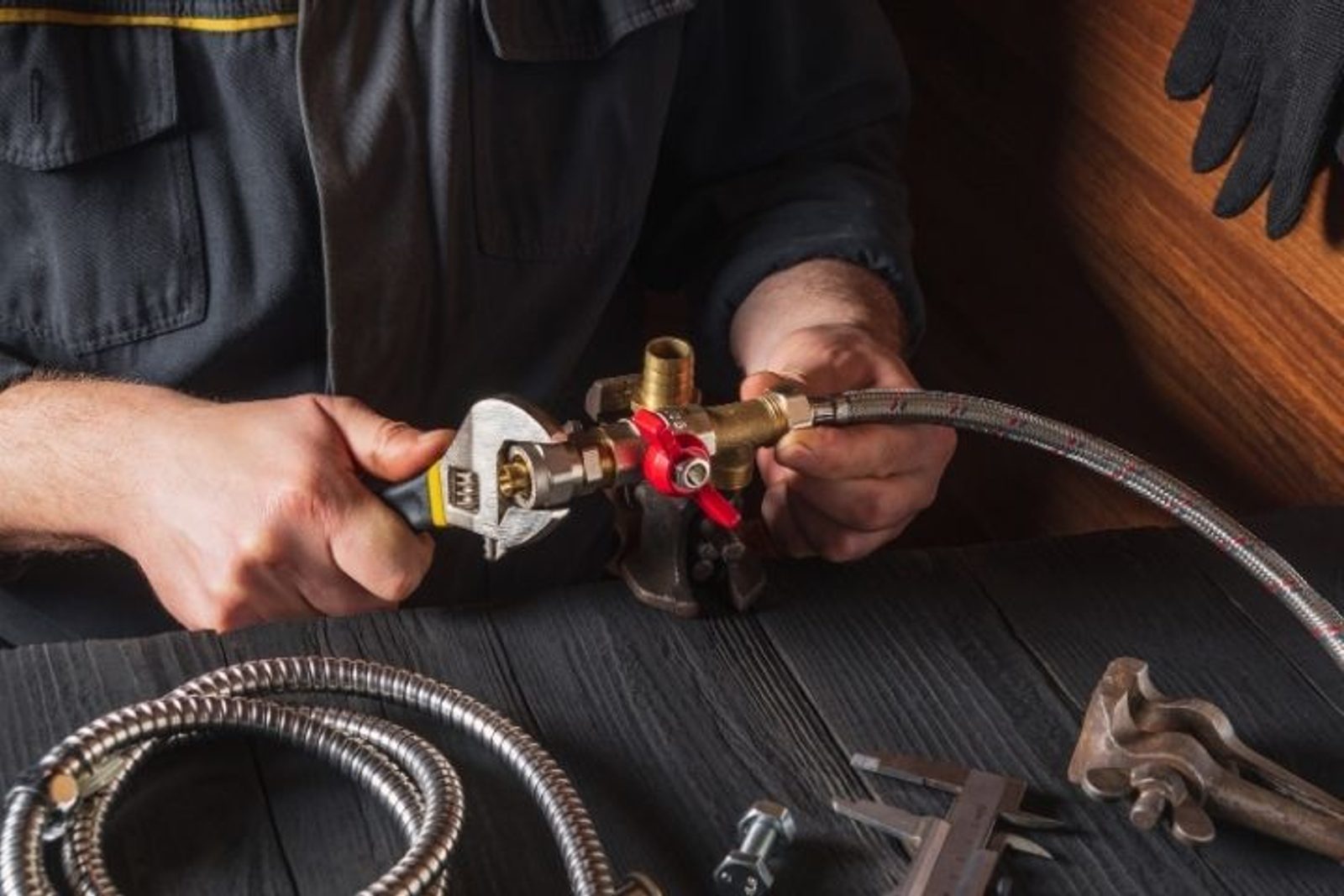 Technician connecting a flexible gas line for an outdoor kitchen appliance installation
