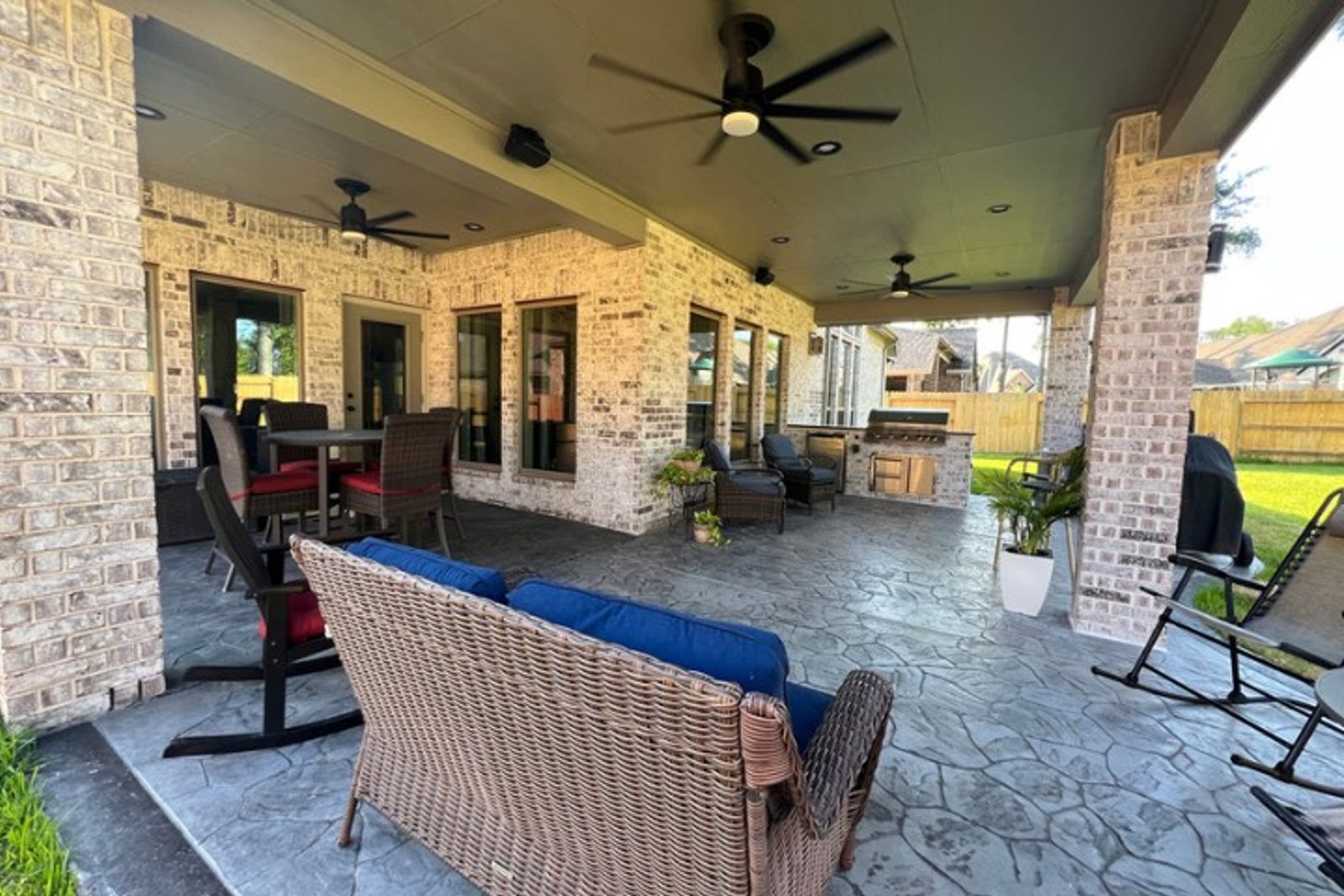 Covered outdoor kitchen and lounge area designed for backyard entertaining