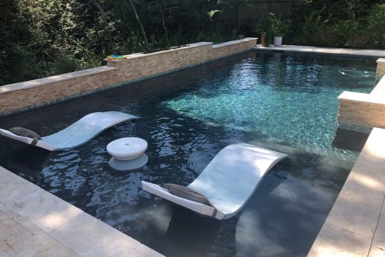 Custom swimming pool with tanning ledge lounge chairs design