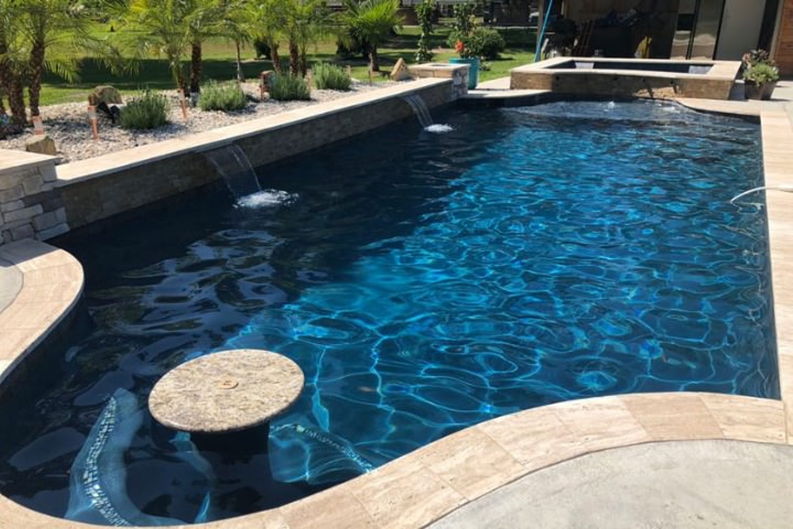 Luxury pool featuring sleek sheer descent waterfalls, creating a modern elegant look