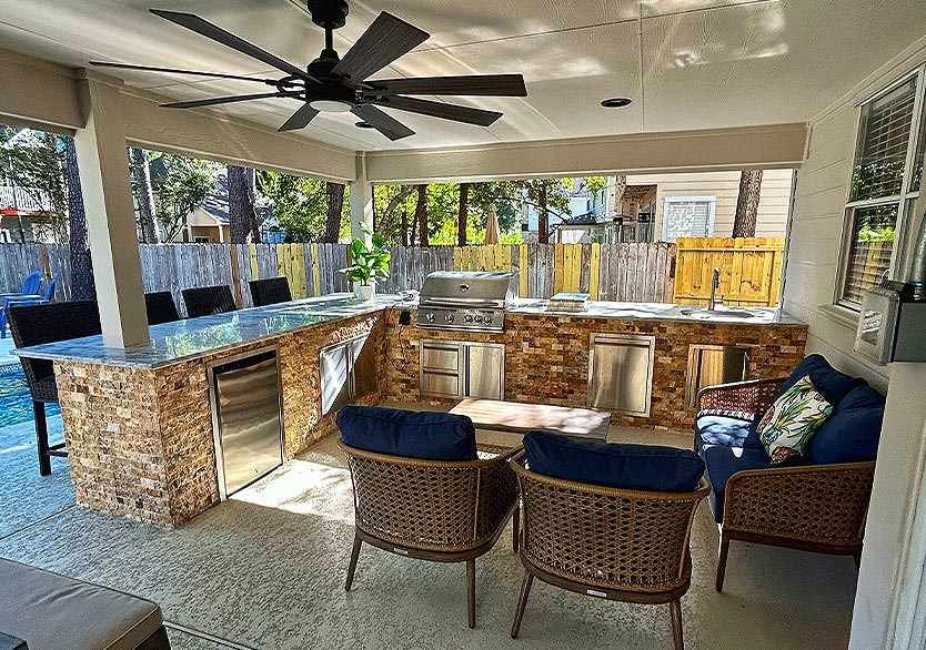 Luxury outdoor patio with kitchen and lounge area designed by top Houston outdoor living contractor