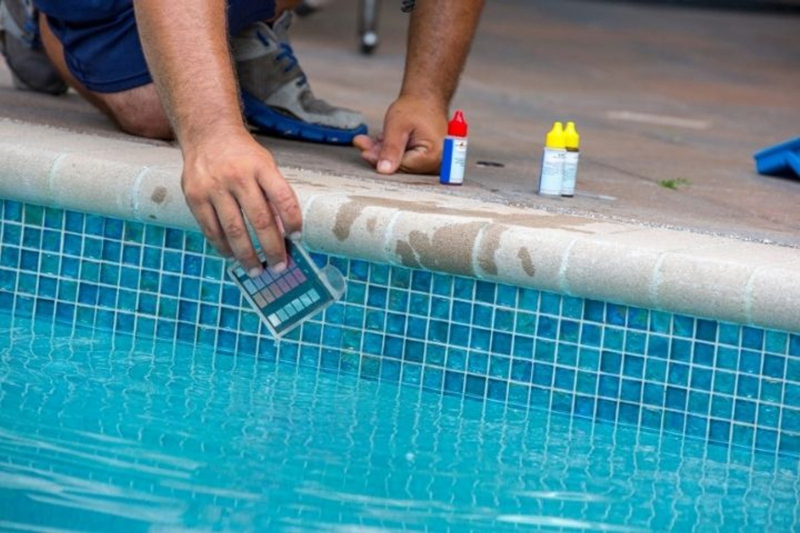 Pool technician testing swimming pool water chemistry after heavy rain