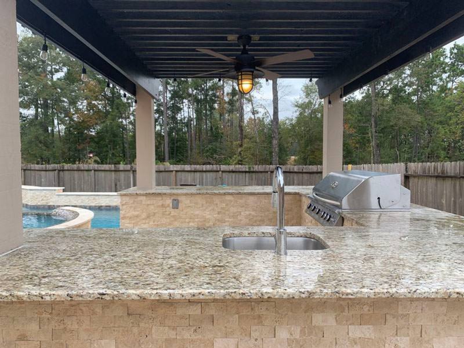 Outdoor kitchen in Houston showcasing a modern patio design with a sink and grilling area