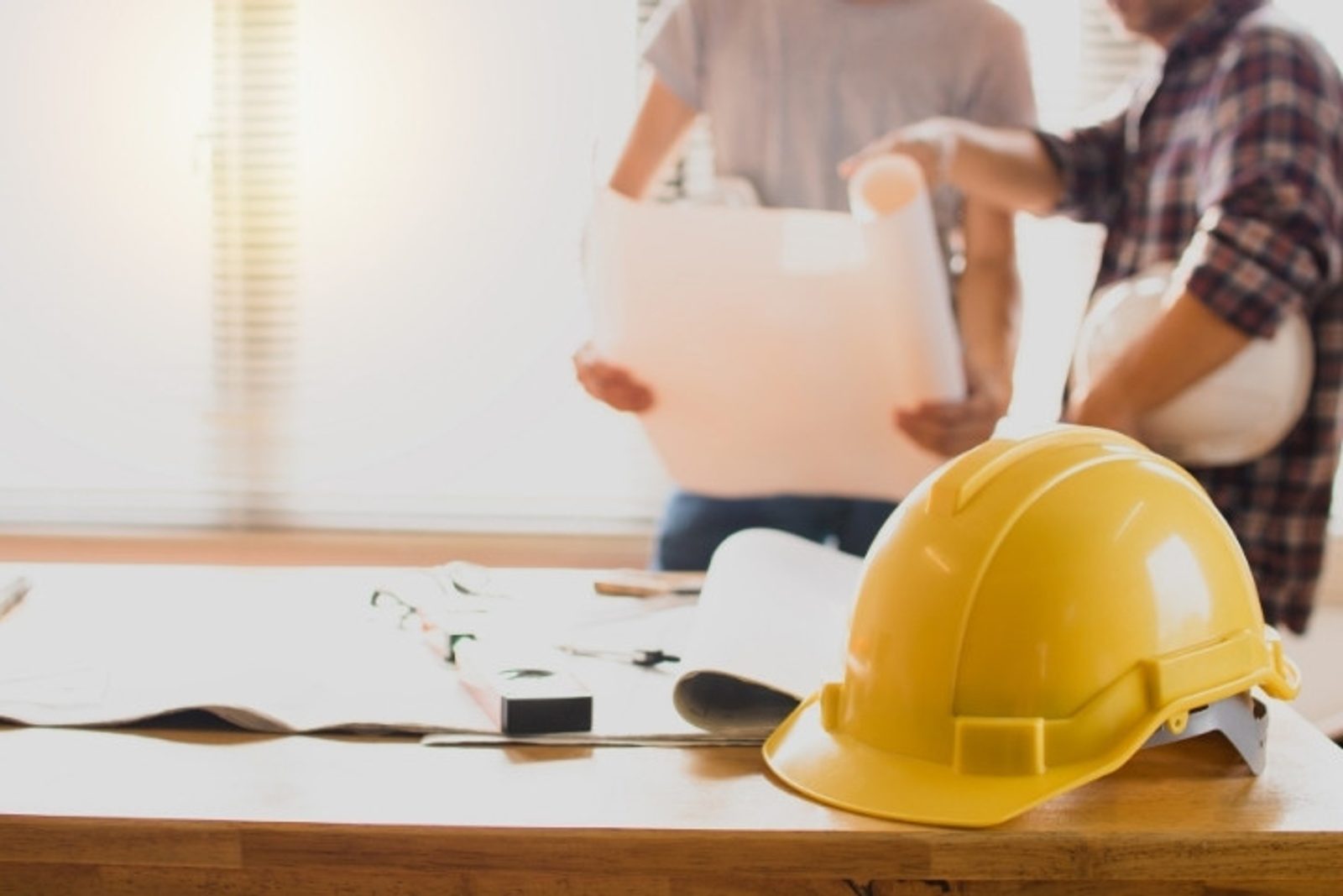 Pool contractor consultation with homeowner, reviewing custom pool construction plans