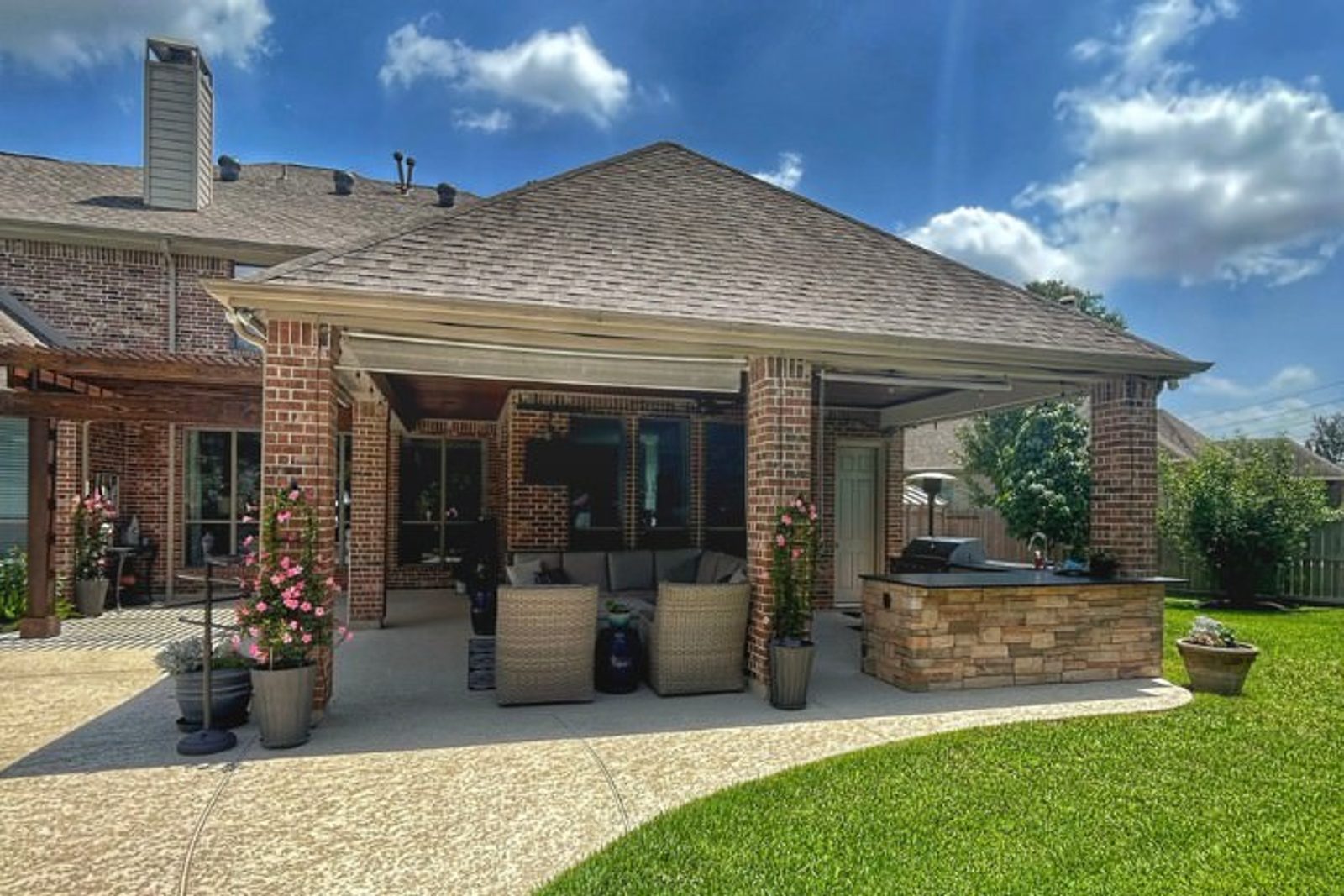 Beautifully designed outdoor living space with a covered patio and kitchen in a Houston backyard
