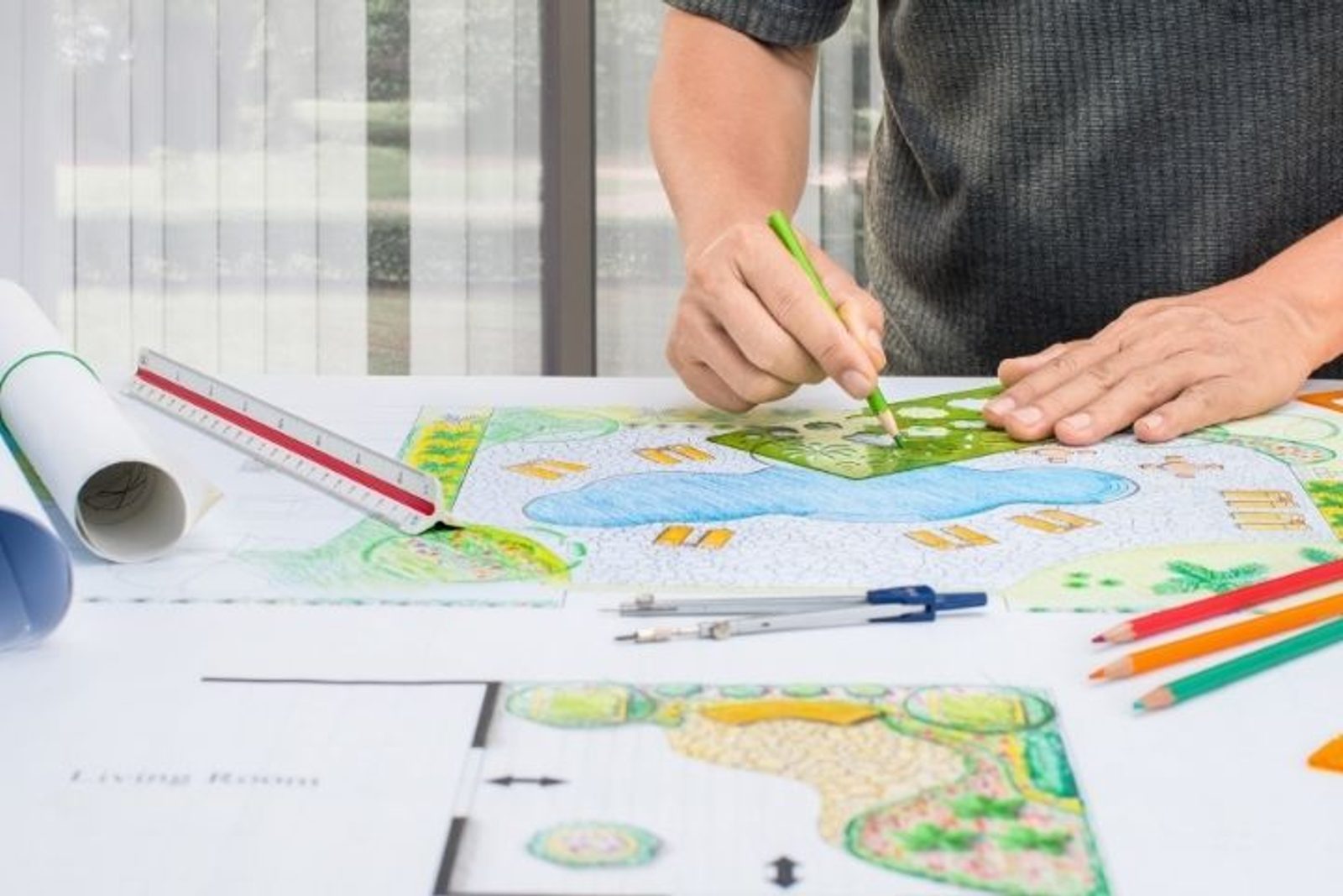 Designer drawing a detailed layout for a pool and surrounding patio