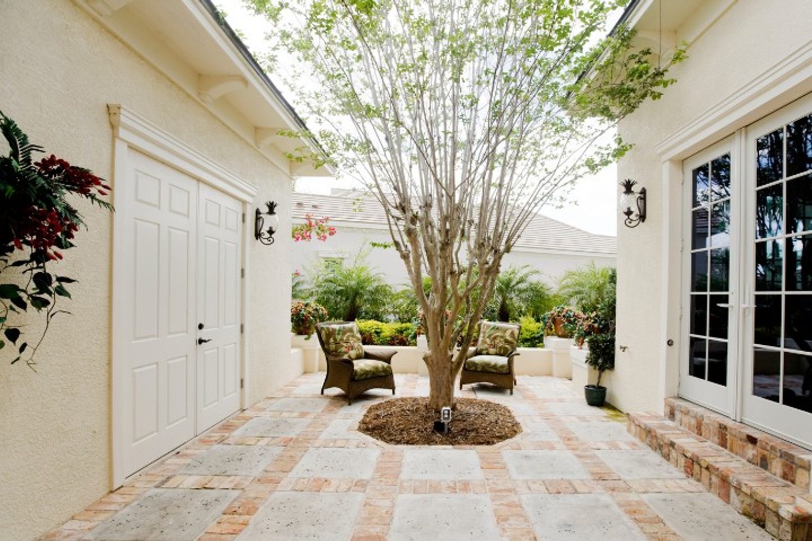 Classic courtyard design featuring warm brick and a central tree, blending vintage charm with balance