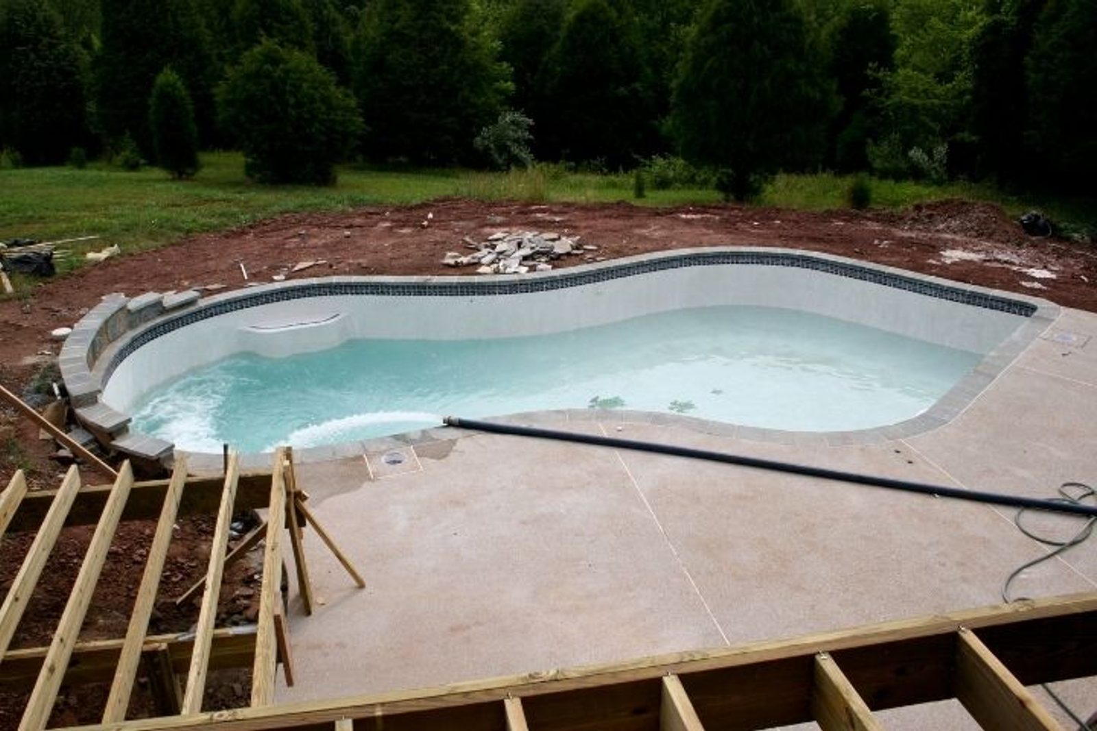 Houston swimming pool deck under renovation with construction framing around the pool area