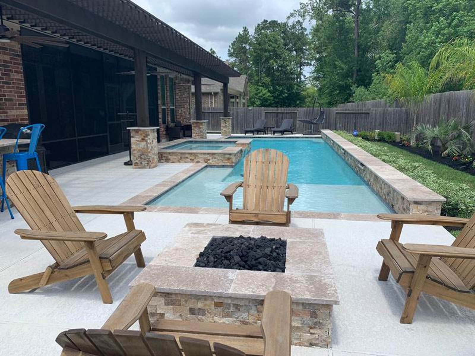 Modern outdoor space with a custom pool, spa, and firepit seating area
