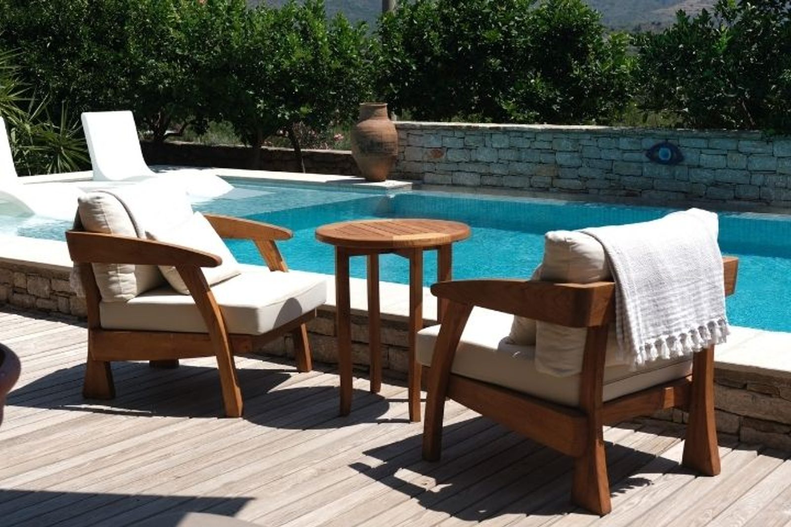 Wooden lounge chairs with cushions beside a Houston pool