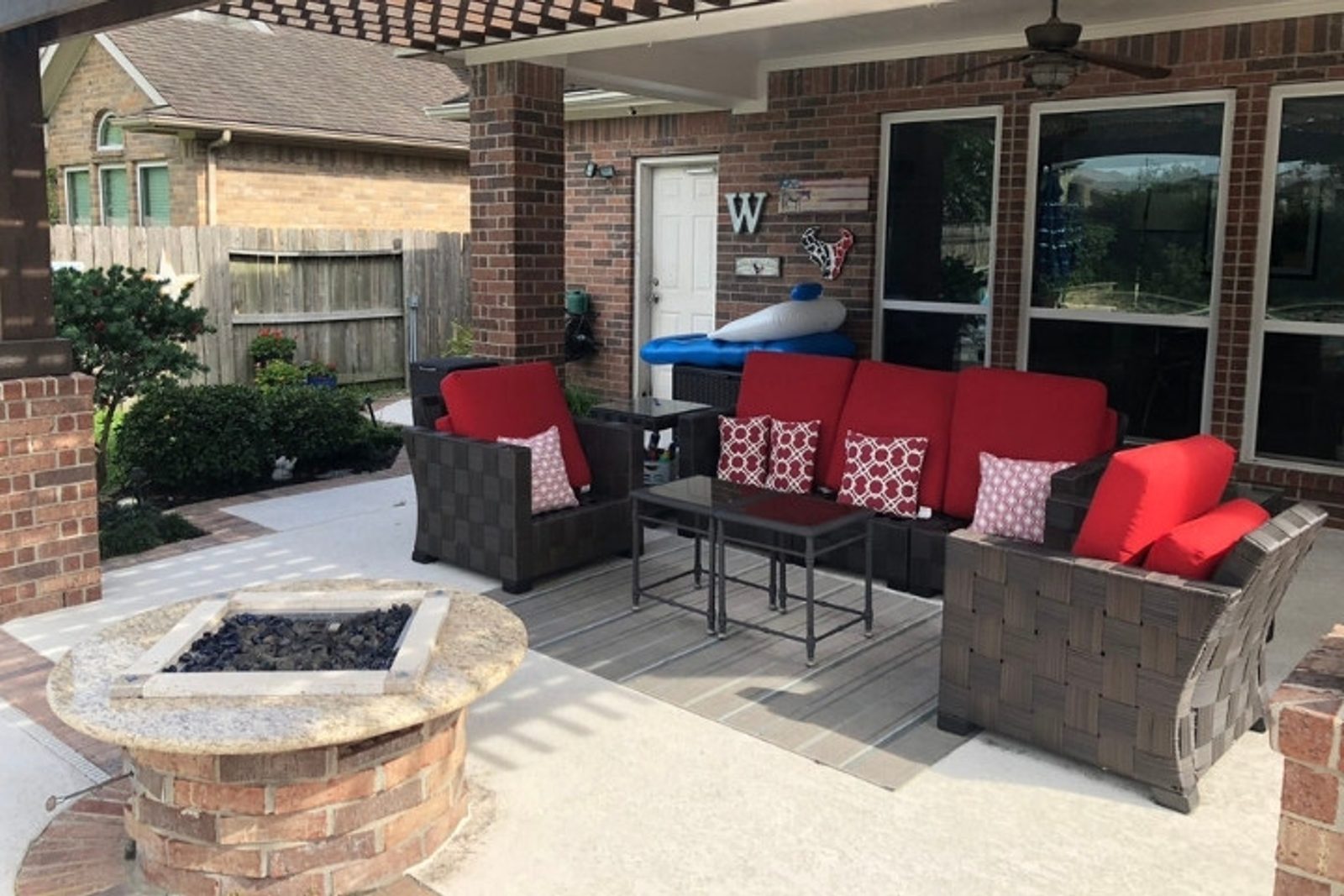 Backyard lounge setup with woven patio furniture and fire pit feature