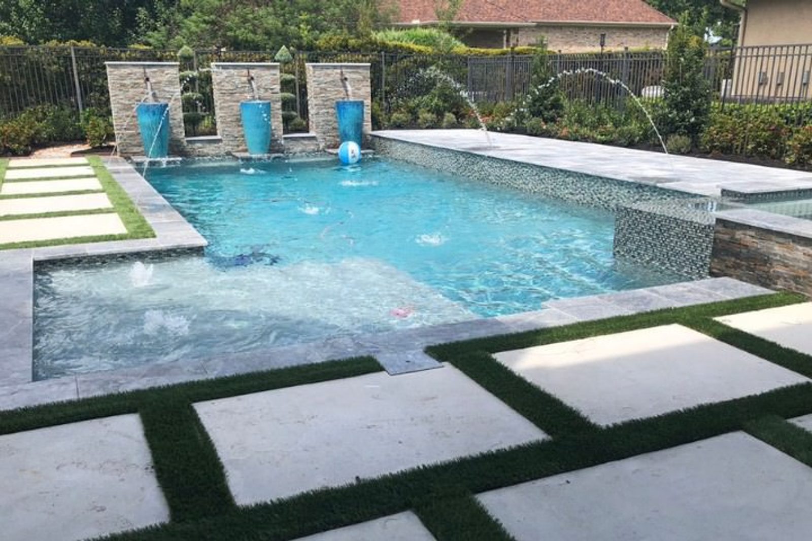 Stylish pool with deck jets shooting synchronized water arcs