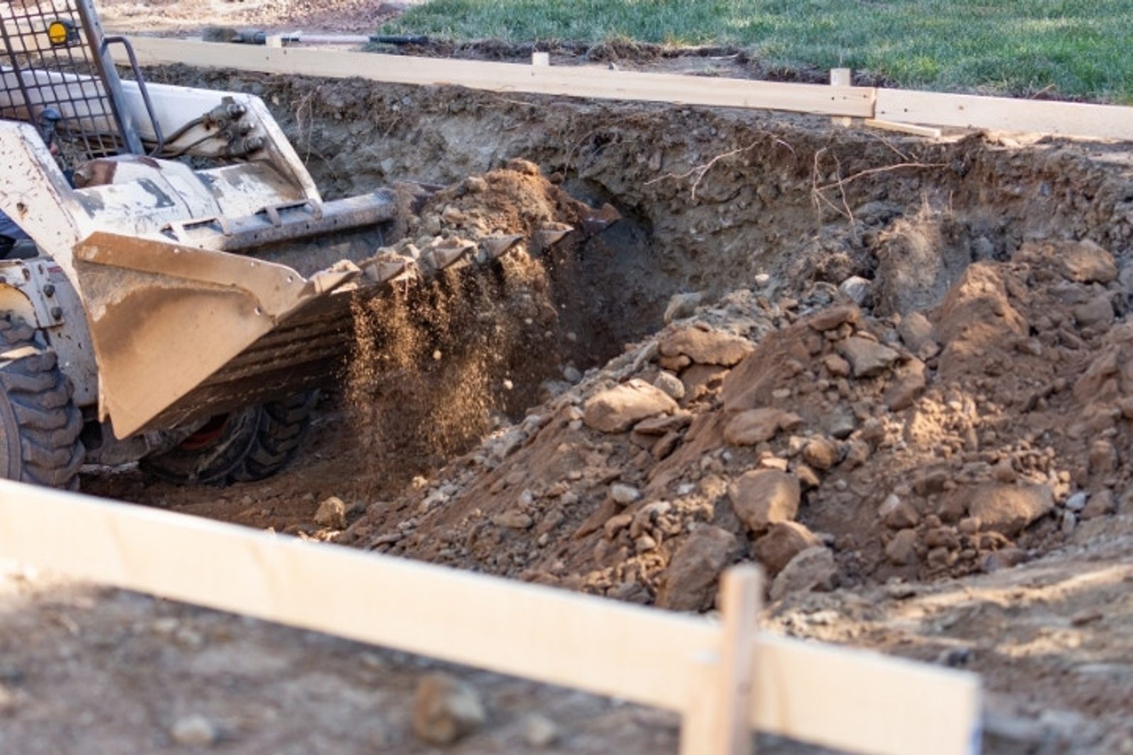 Heavy equipment preparing the foundation for an infinity pool build