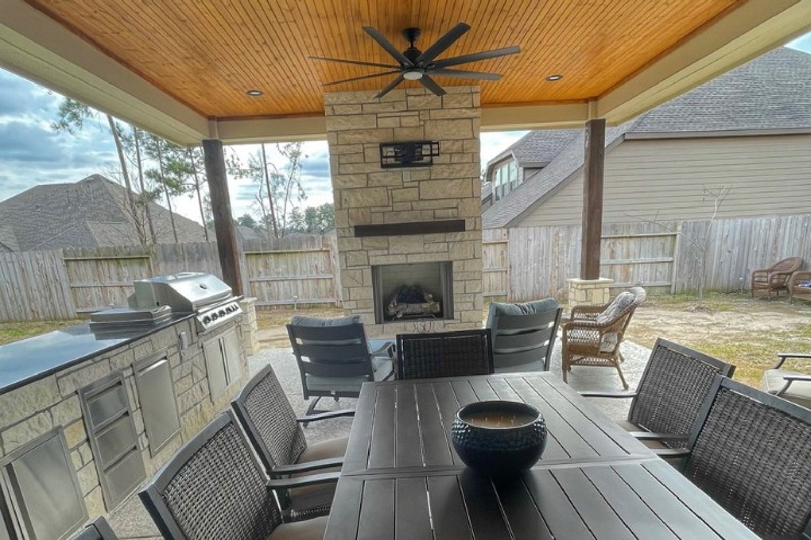 Outdoor living area renovation with stone fireplace and outdoor kitchen