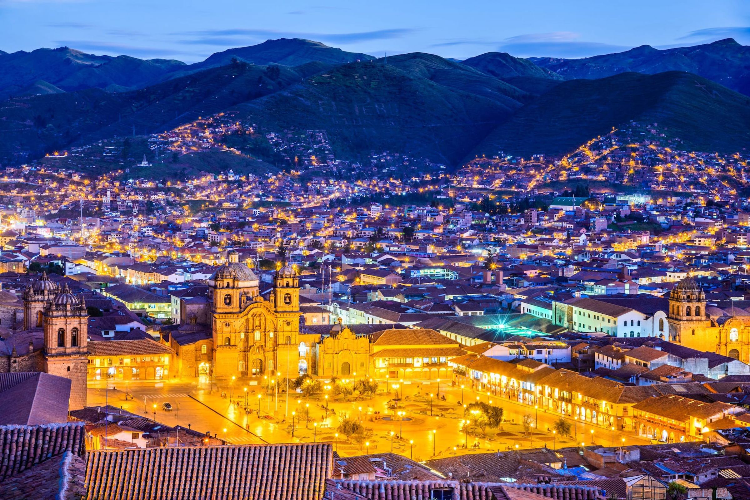 Cusco at dusk with the city lights spread across the valley