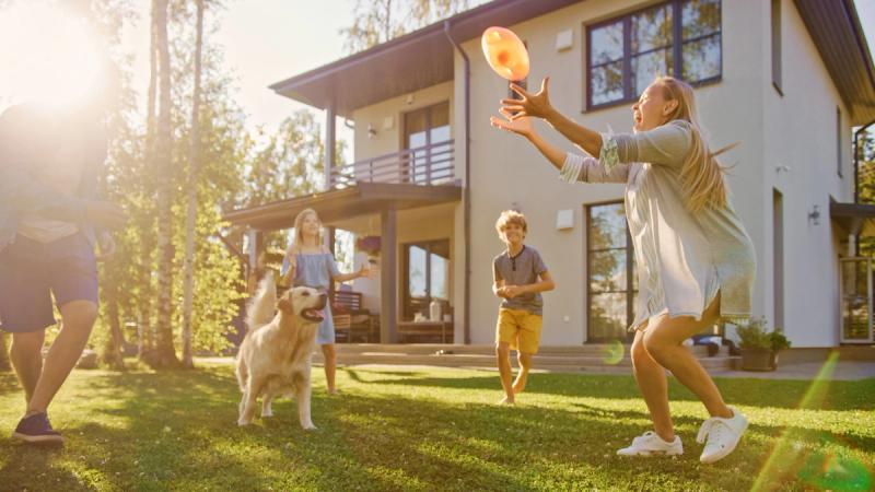 Family playing frisbee in a garden