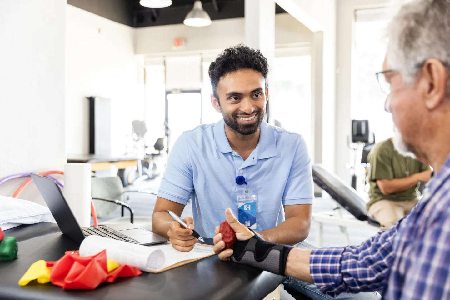 An occupational therapist working with a patient on hand therapy.