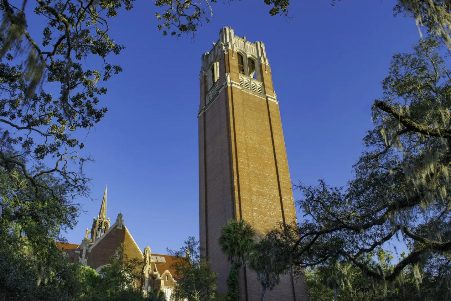A historic university clock tower against a blue sky.