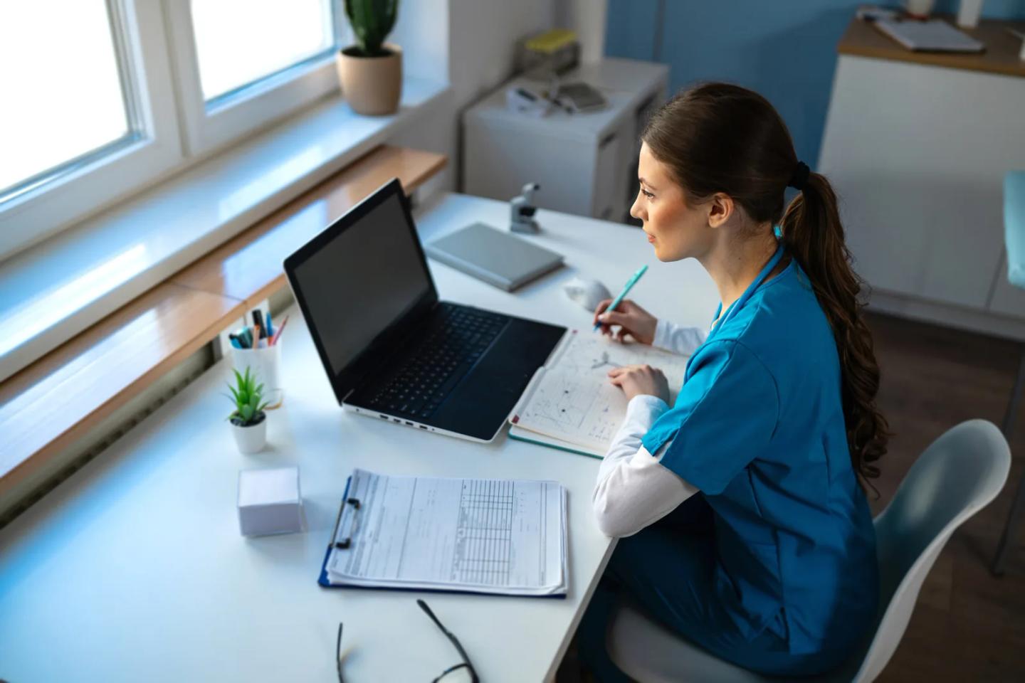 A clinician working through online coursework at a desk.
