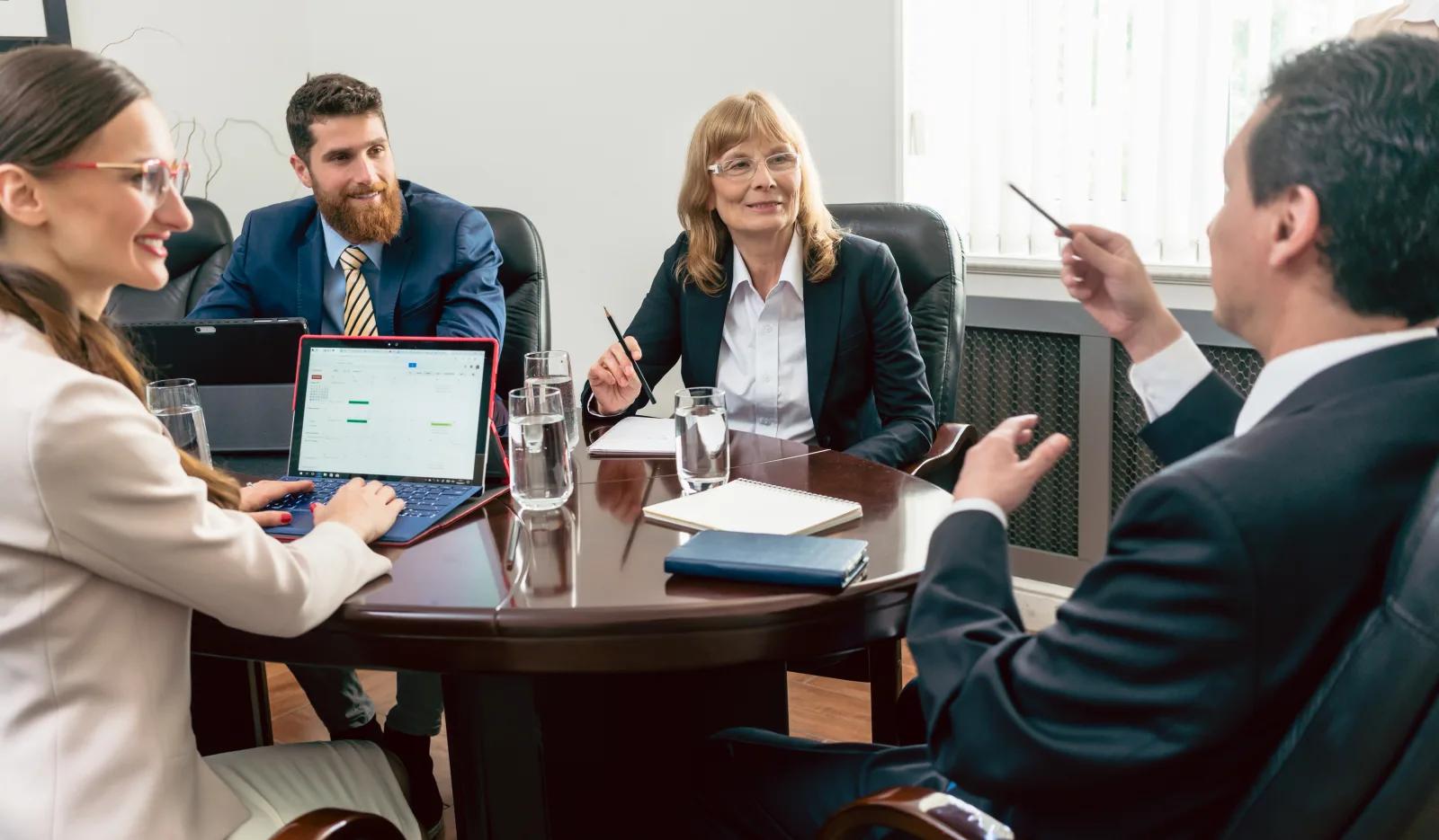 University leaders discussing program growth around a meeting table.