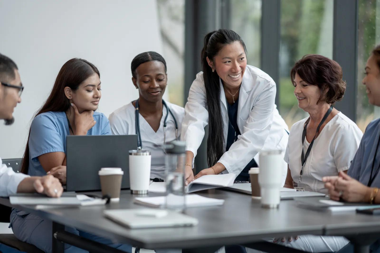 A diverse team of educators and clinicians collaborating in a meeting.