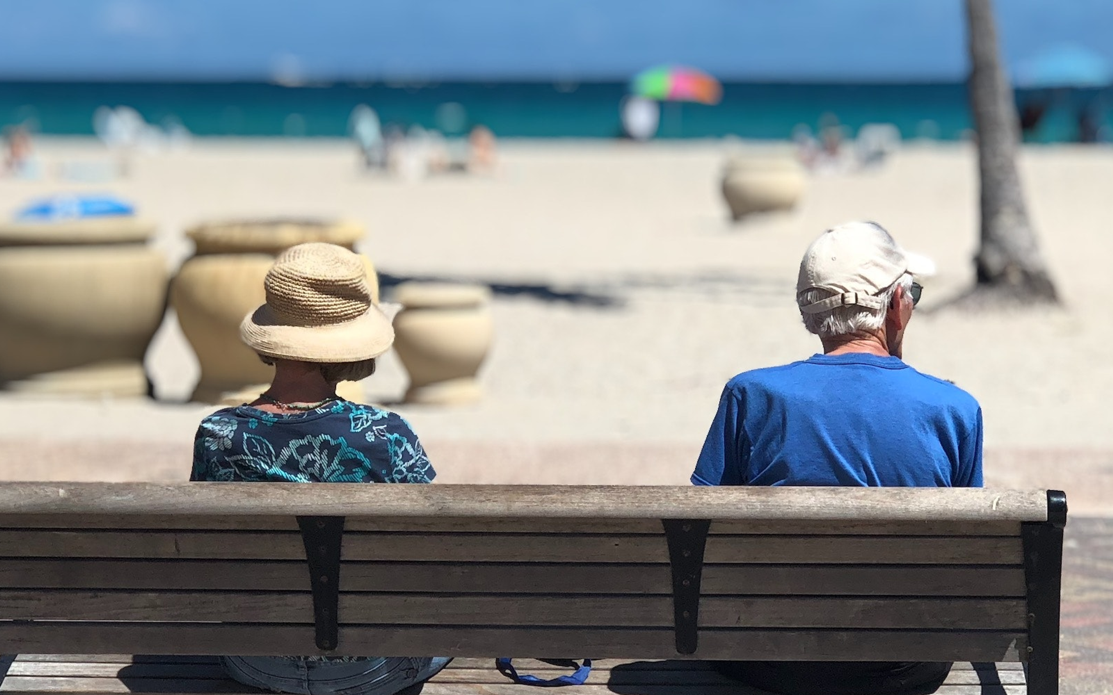 Man and Woman Sitting on Brown Wooden Bench in Hollywood, FL, United States
