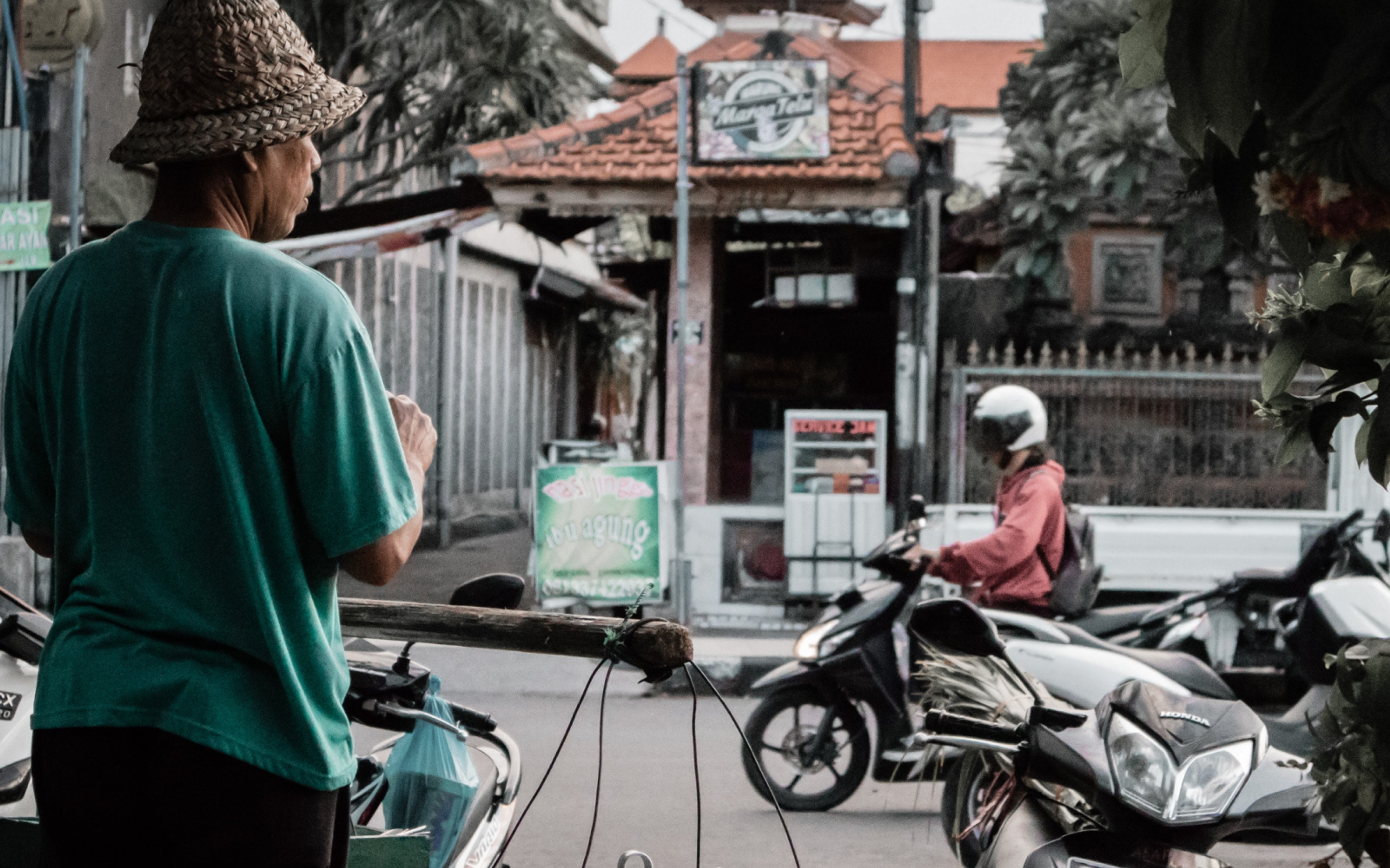 Man Standing Beside Black Motorcycle in Marga, Bali, Indonesia