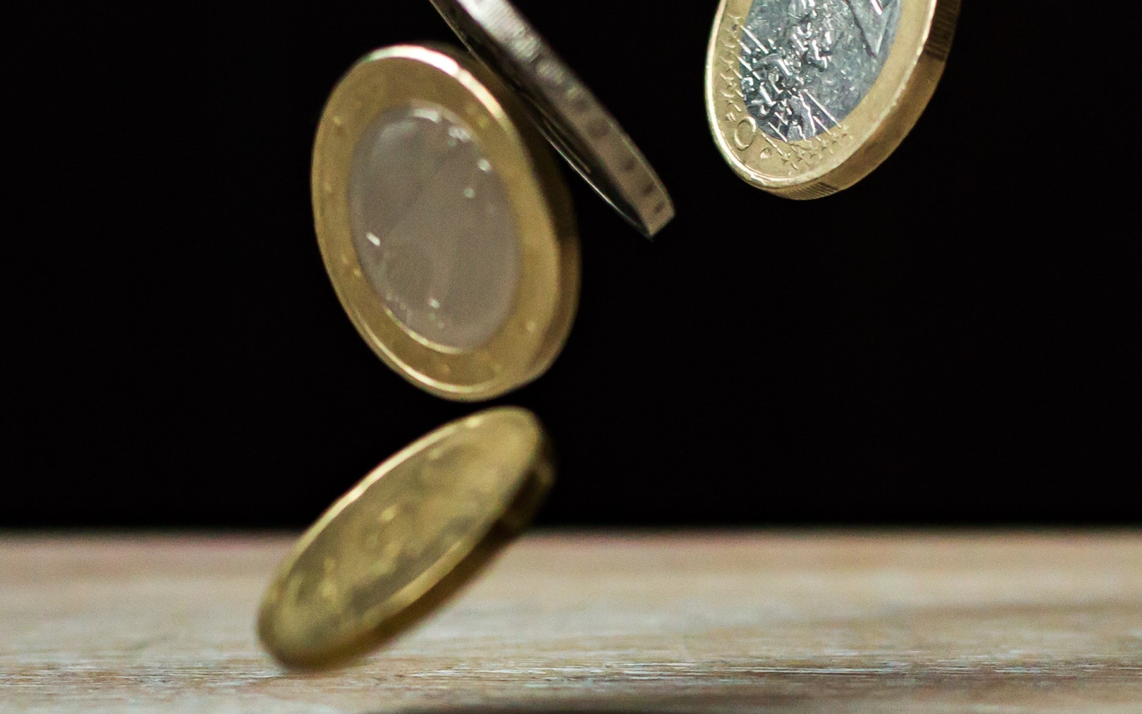 Coins dropping on Brown Wood
