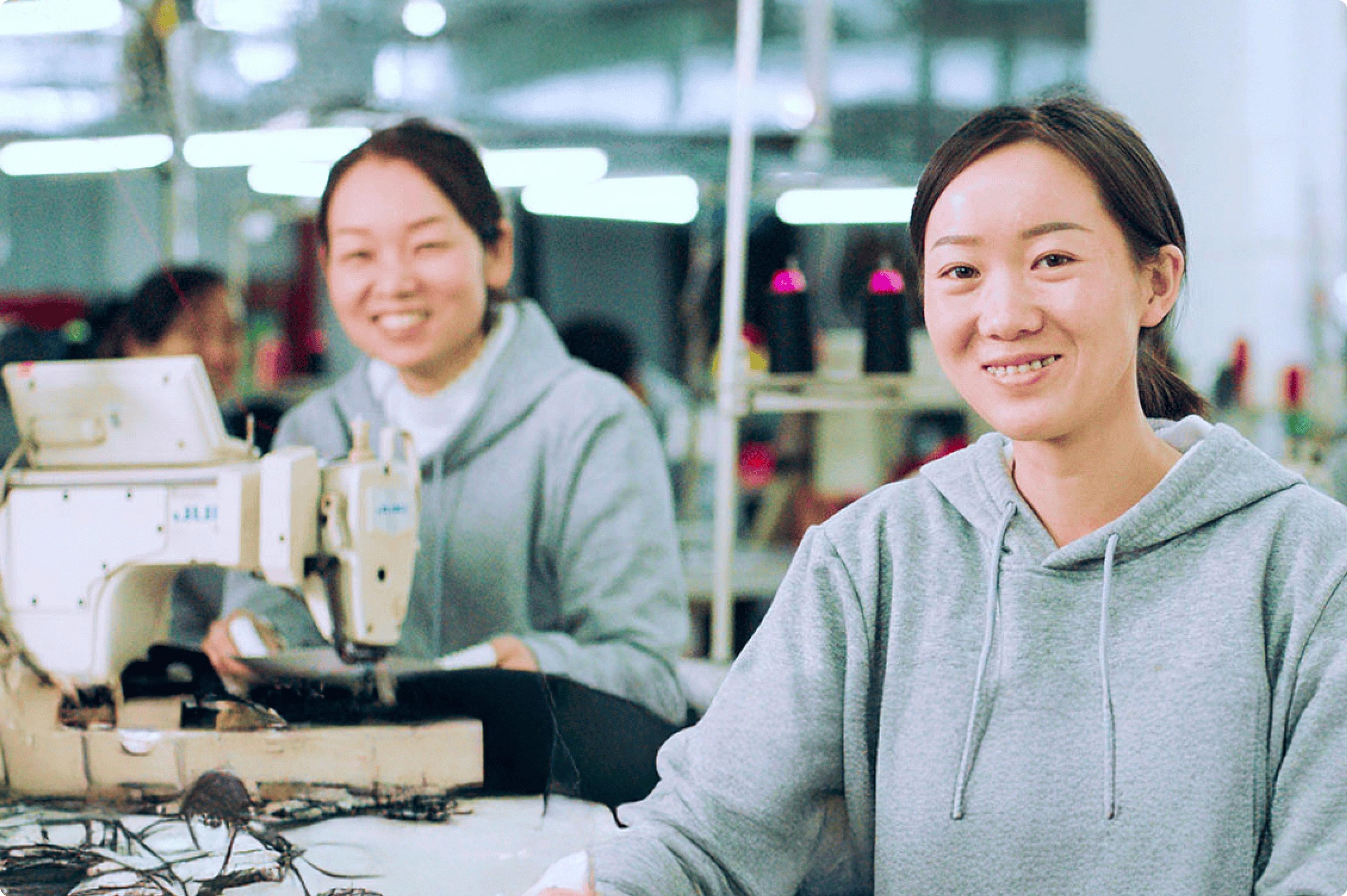 Photo of women smiling at an apparel factory