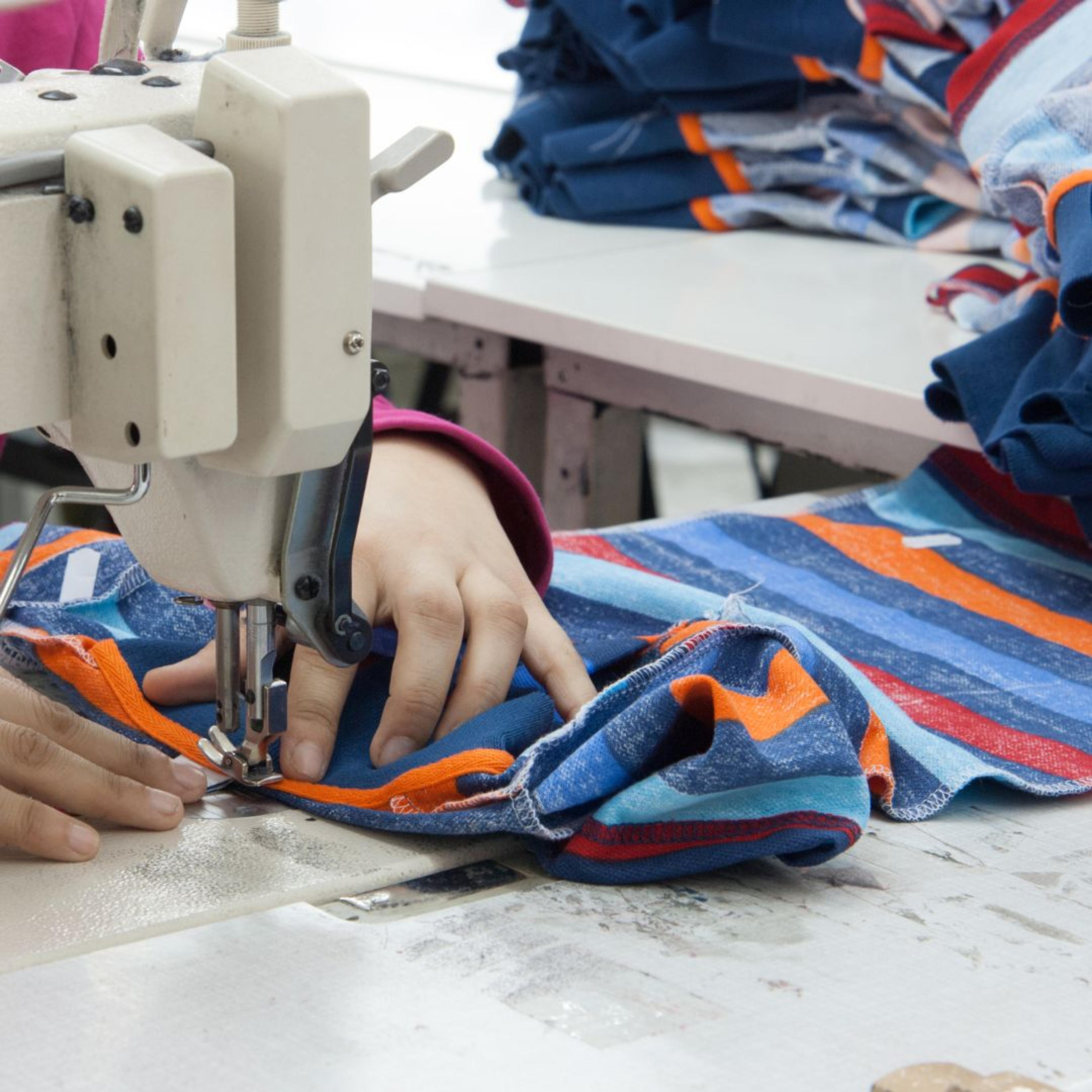 A sewing machine at work in apparel manufacturer facility 